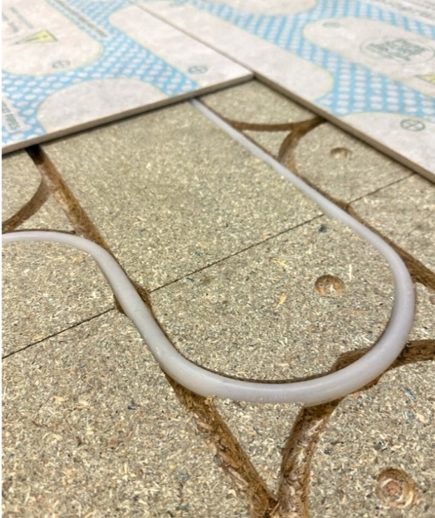 Pipe recessed in channel with printed cover panel aligned over the pipe path